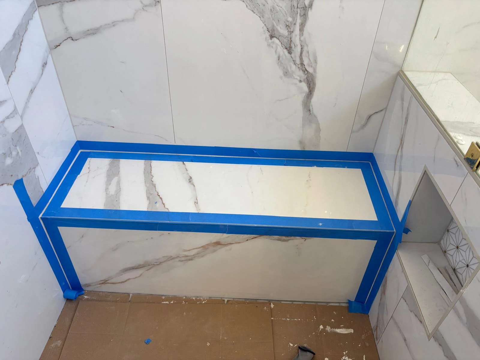 Shower bench during installation with blue protective tape